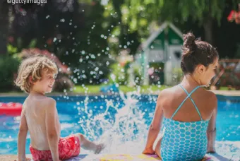 Twee kinderen met voeten aan het plonzen in zwembad